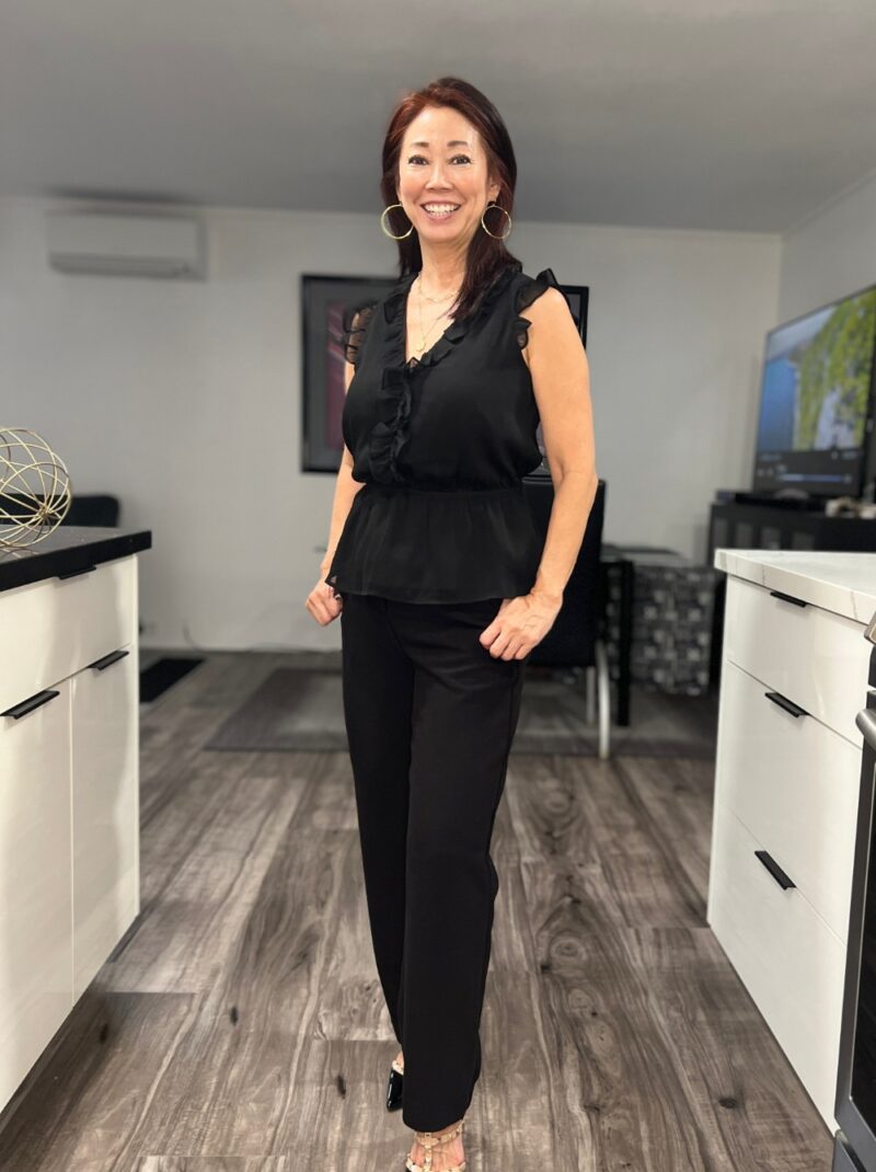 black pants with sleeveless ruffled black top